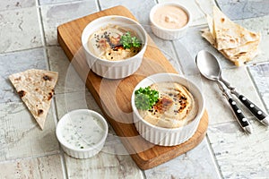 Bowl of hummus, traditional Jewish, Arabian, Middle Eastern food from chick-peas with deeps and with pita flatbread on ceramic