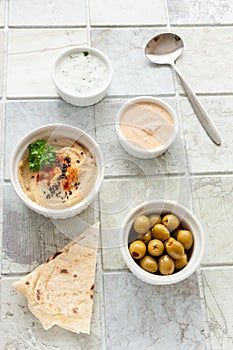 Bowl of hummus, traditional Jewish, Arabian, Middle Eastern food from chick-peas with deeps and with pita flatbread on ceramic