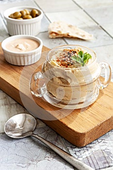 Bowl of hummus, traditional Jewish, Arabian, Middle Eastern food from chick-peas with deeps and with pita flatbread on ceramic