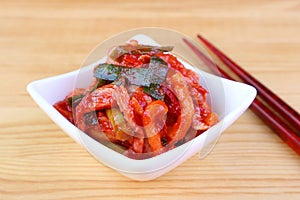 A Bowl of Iconic Korean Dish Kimchi,  with a Pair of Chopsticks on Wooden Table