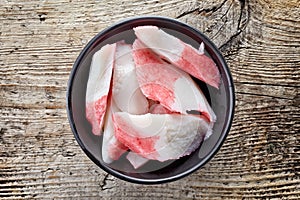 Bowl of imitation crabmeat on wood, from above