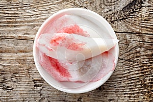 Bowl of imitation crabmeat on wood, from above