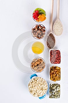 Bowl with ingredients for cooking  homemade granola on white background. Healthy snak.