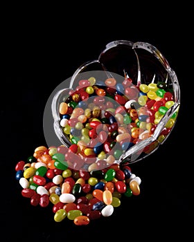 Bowl of Jelly Beans Tipped Over on Black Background