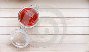 Bowl with ketchup on wooden background