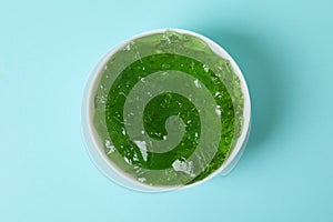 Bowl of kiwi jelly on blue background