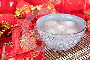 A bowl of Lantern Festival and festival red envelopes and gold ingots on the decorated red background