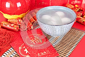 A bowl of Lantern Festival Lantern and festival red envelopes on the background covered with festive decorations. The Chinese char