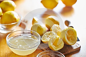 Bowl of lemon juice and pile of freshly squeezed lemons