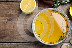 Bowl of lemon sauce and ingredients on wooden table, flat lay with space for text. Delicious salad dressing