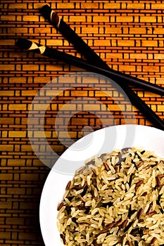 Bowl with long-grain black and white rice over bamboo background