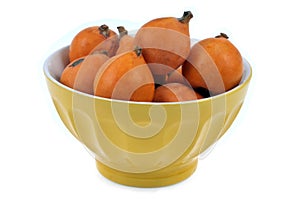 Bowl of loquats on a white background