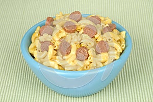 Bowl of macaroni and cheese with hotdog slices
