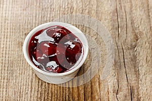 Bowl of marmalade on wooden table