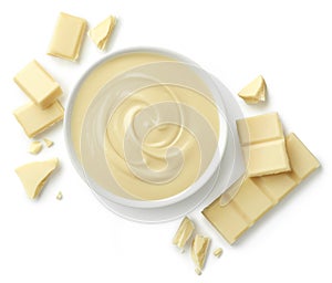 Bowl of melted white chocolate and pieces of chocolate bar isolated on white background