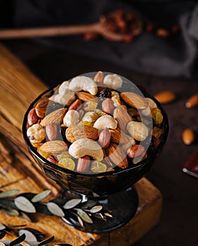 Bowl with mixed organic nuts on wooden board