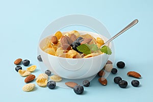 Bowl with muesli, almond, mint and blueberry  on blue background