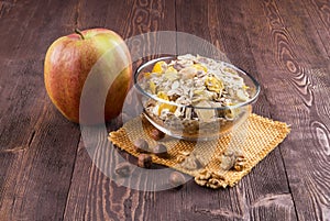 Bowl of muesli, apple, nuts, flakes, candied for a nutritious b