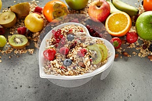 Bowl of muesli near ripe fruits