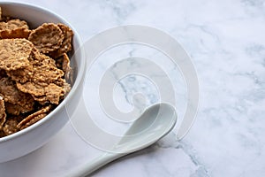 Bowl of multigrain cereal with spoon on marble table background. Healthy diet breakfast.
