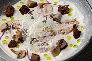 A bowl of Mushroom Cream Soup with fried champignons and chicken. Winter, autumn hot soup concept