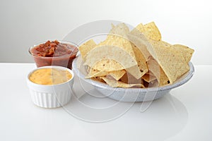 Bowl of nacho chips with salsa and cheese photo