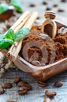 Bowl with natural ground coffee and cinnamon.