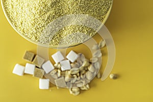 Bowl of Nigerian Yellow Garri in Yellow bowl with Peanuts and Sugar photo