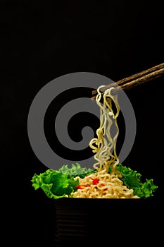 Bowl of noodles with vegetables isolated on black,Dried chinese