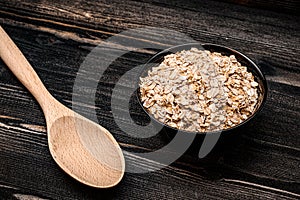 bowl of oat cereal and dark wooden spoon