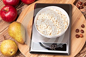 Bowl of oat flakes on the kitchen scales