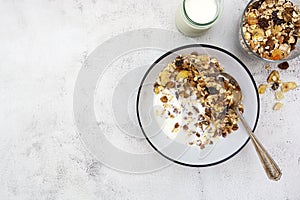 Bowl of oatmeal cereal. Whole oats, granola with dried fruit and blueberry, milk and honey. Healthy food breakfast. Copy space