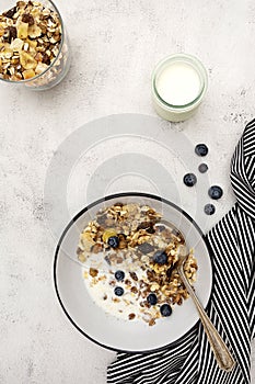 Bowl of oatmeal cereal. Whole oats, granola with dried fruit and blueberry, milk and honey. Healthy food breakfast. Copy space