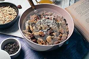 Bowl of oatmeal porridge with banana and nuts.