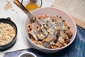 Bowl of oatmeal porridge with banana and nuts.