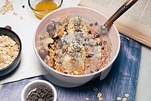 Bowl of oatmeal porridge with banana and nuts.