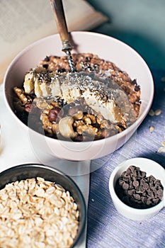 Bowl of oatmeal porridge with banana and nuts.