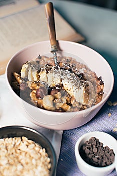 Bowl of oatmeal porridge with banana and nuts.