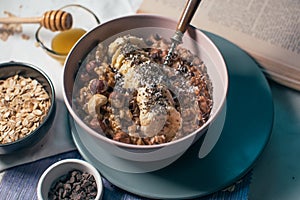 Bowl of oatmeal porridge with banana and nuts.