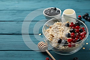 Bowl oatmeal porridge and fruits on wooden background. Cooking breakfast