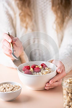 Bowl of oatmeal porridge with raspberries and cashew