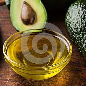 Bowl with oil and fresh avocadoes