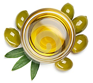 Bowl of olive oil and green olives with leaves