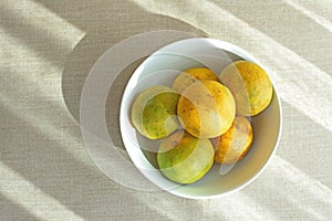 Bowl of orange fruit on fabric