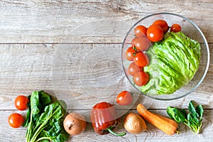 Bowl of organic and bio fresh vegetables tomato, peppers, carrots lies in row on rustic wooden background table with copy space.