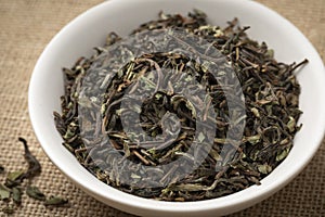 Bowl with organic Nepal Oolong Jun Chiyabari dried tea leaves photo