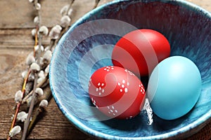 Bowl with painted Easter eggs on table