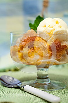 A Bowl Of Peach Cobbler With Vanilla Ice Cream
