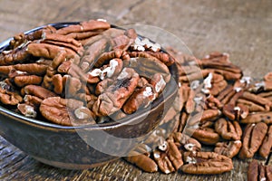 Bowl with pecan on rustic wooden table photo