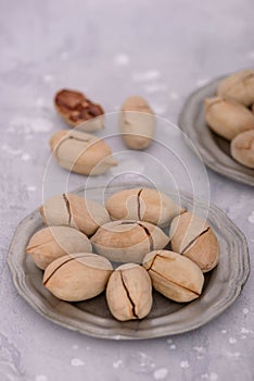 Bowl with pecan nuts on gray stone table